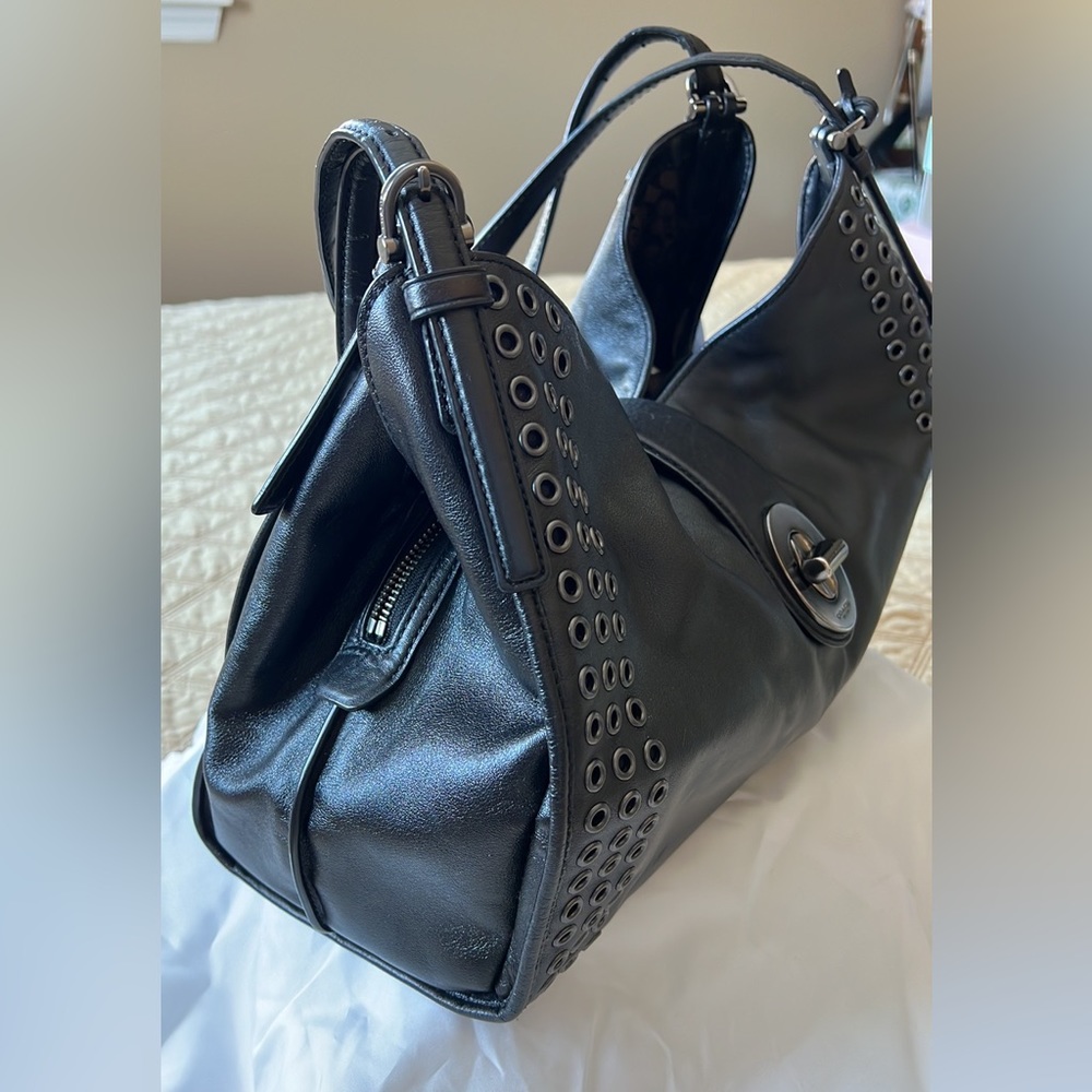Beautiful high end black Coach bag with 2 inside pockets with a middle zipper.